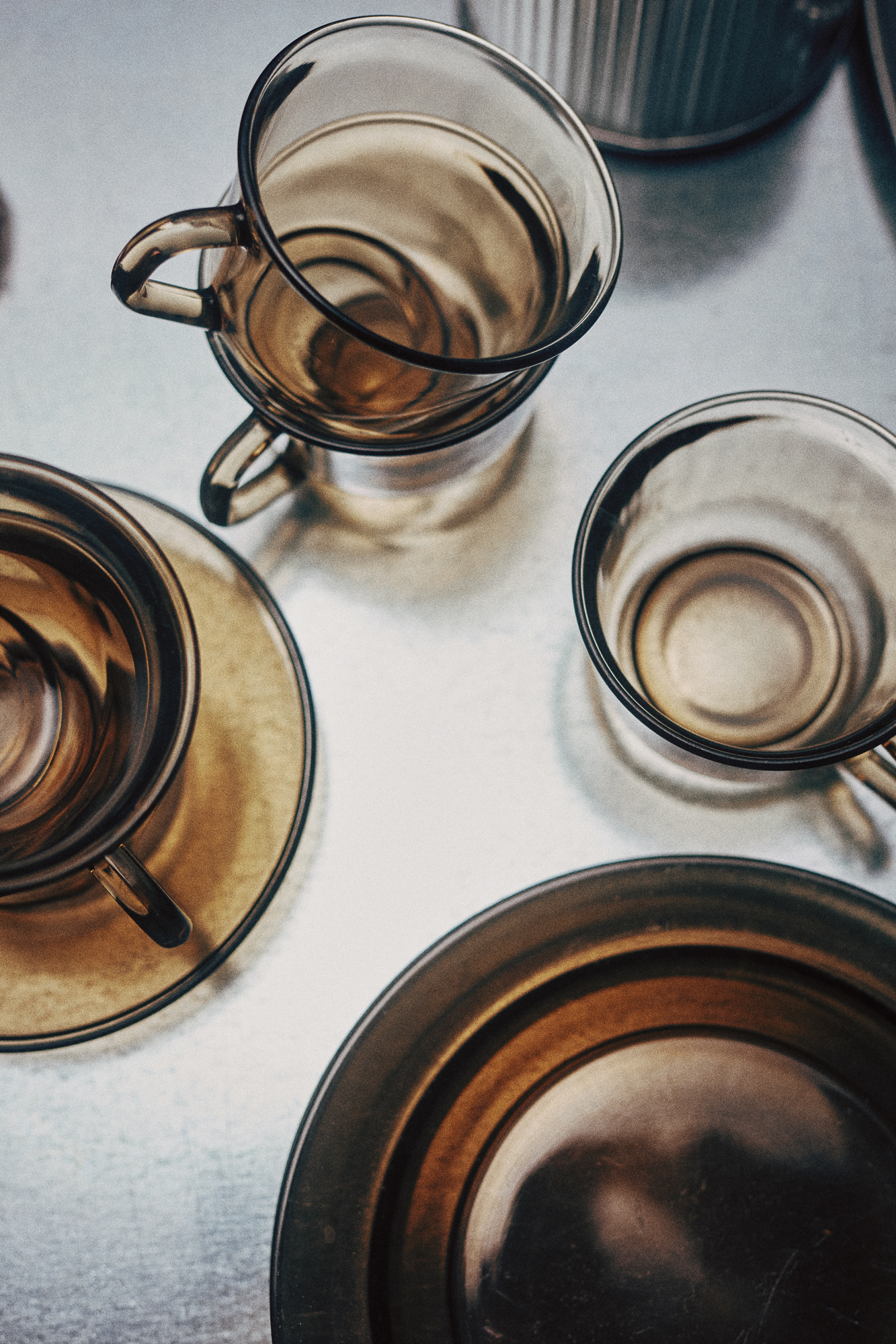 Overhead view of several empty glass teacups and saucers